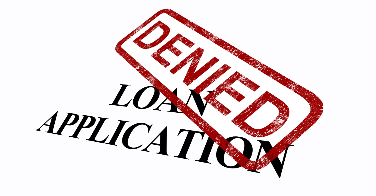The image shows a "Loan Application" with a large "Denied" stamp across it, indicating the application was rejected.