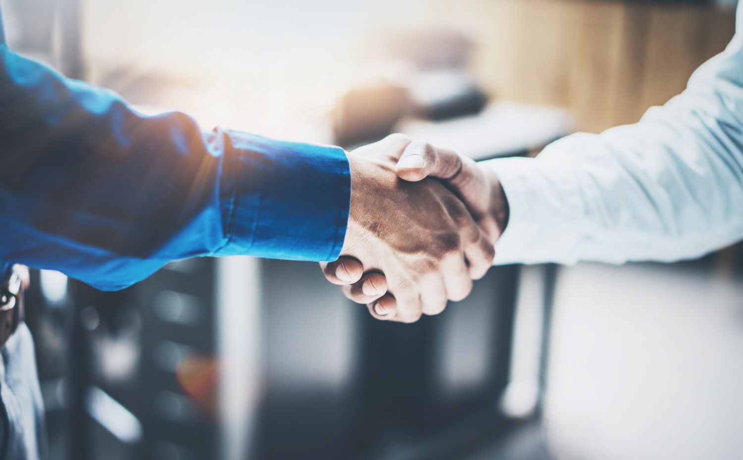 A close-up of two people shaking hands, symbolizing an agreement or business deal.