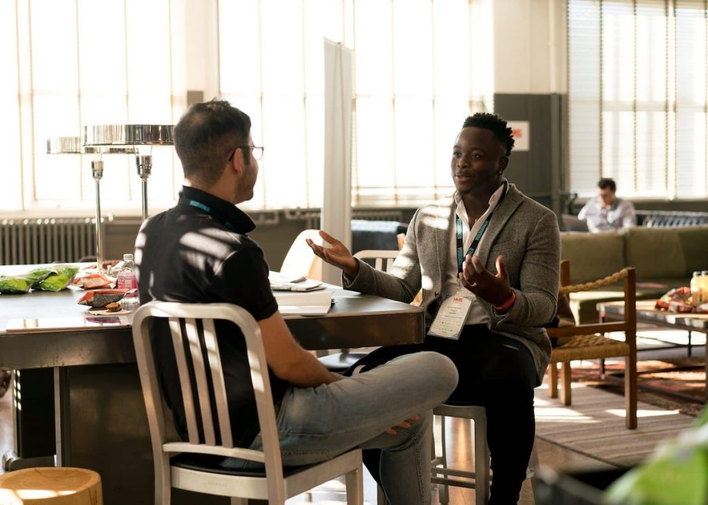 Two colleagues are having an engaging conversation during a break in a bright, modern office space.