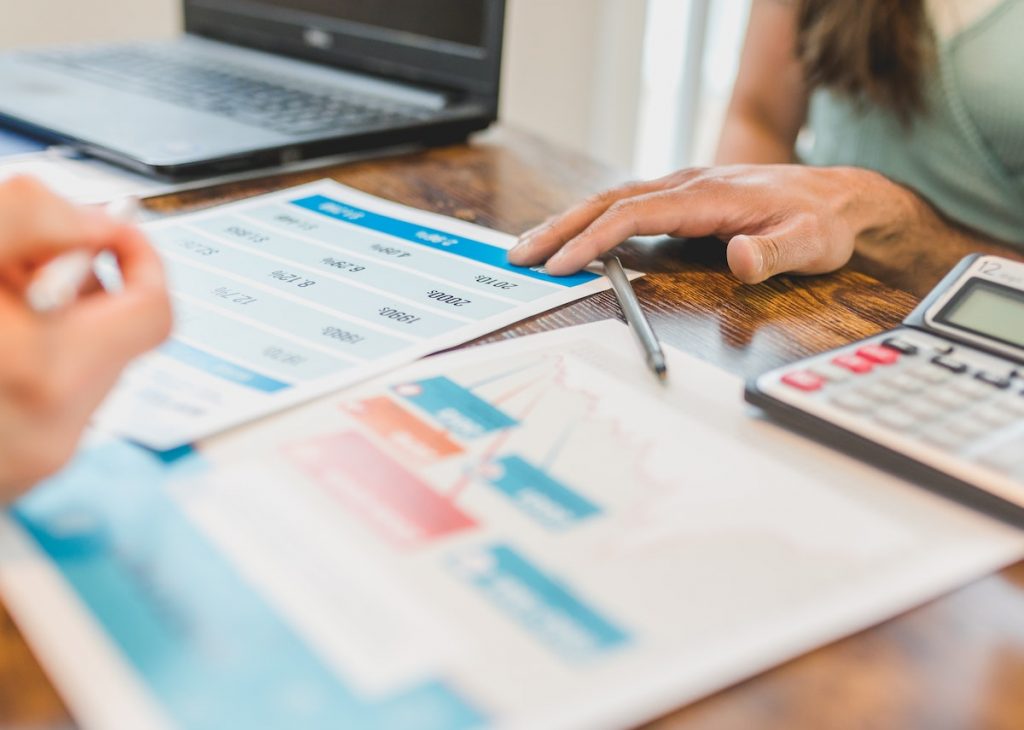 The image shows a person analyzing financial documents