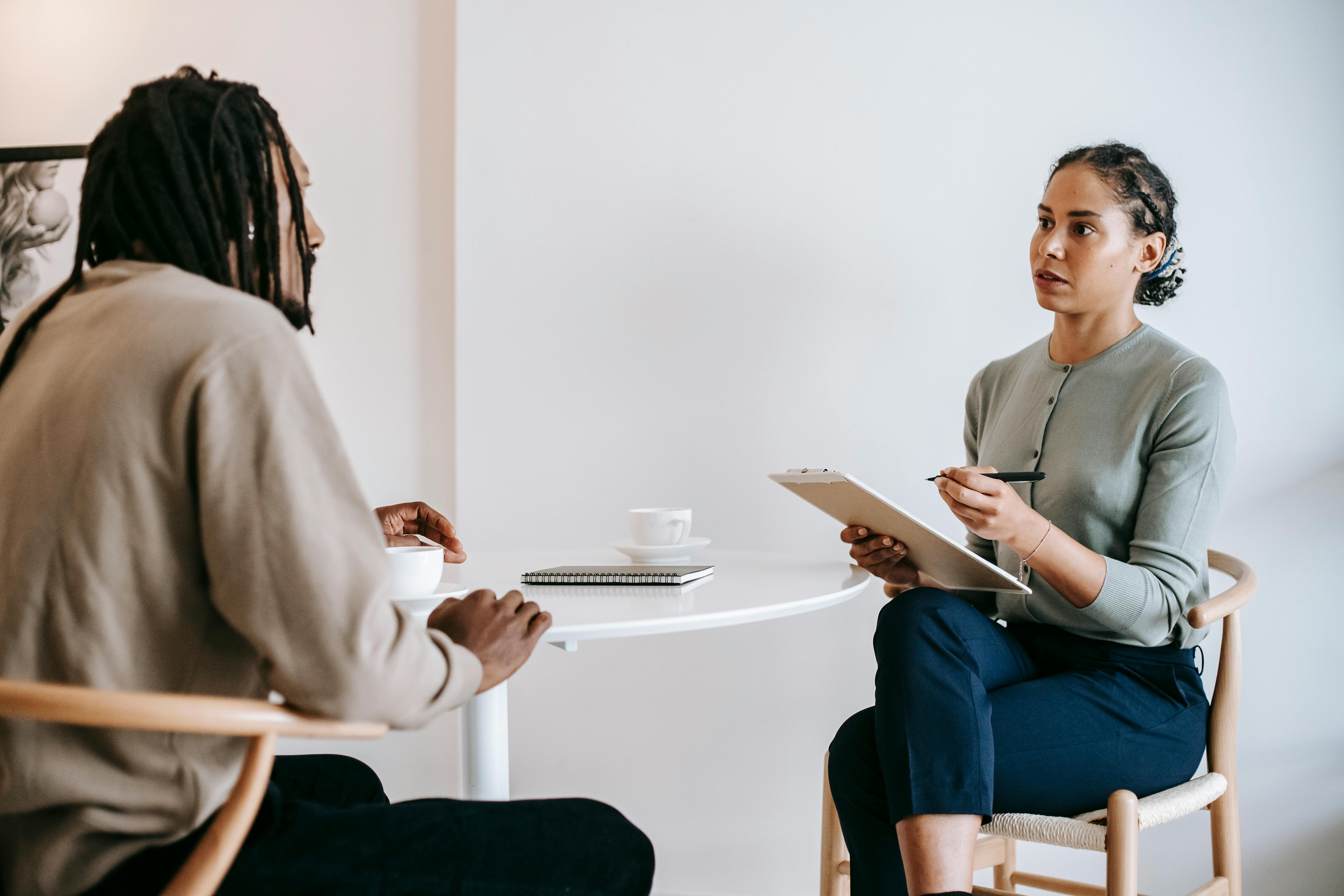 Two women are having a serious conversation during a counseling or therapy session.