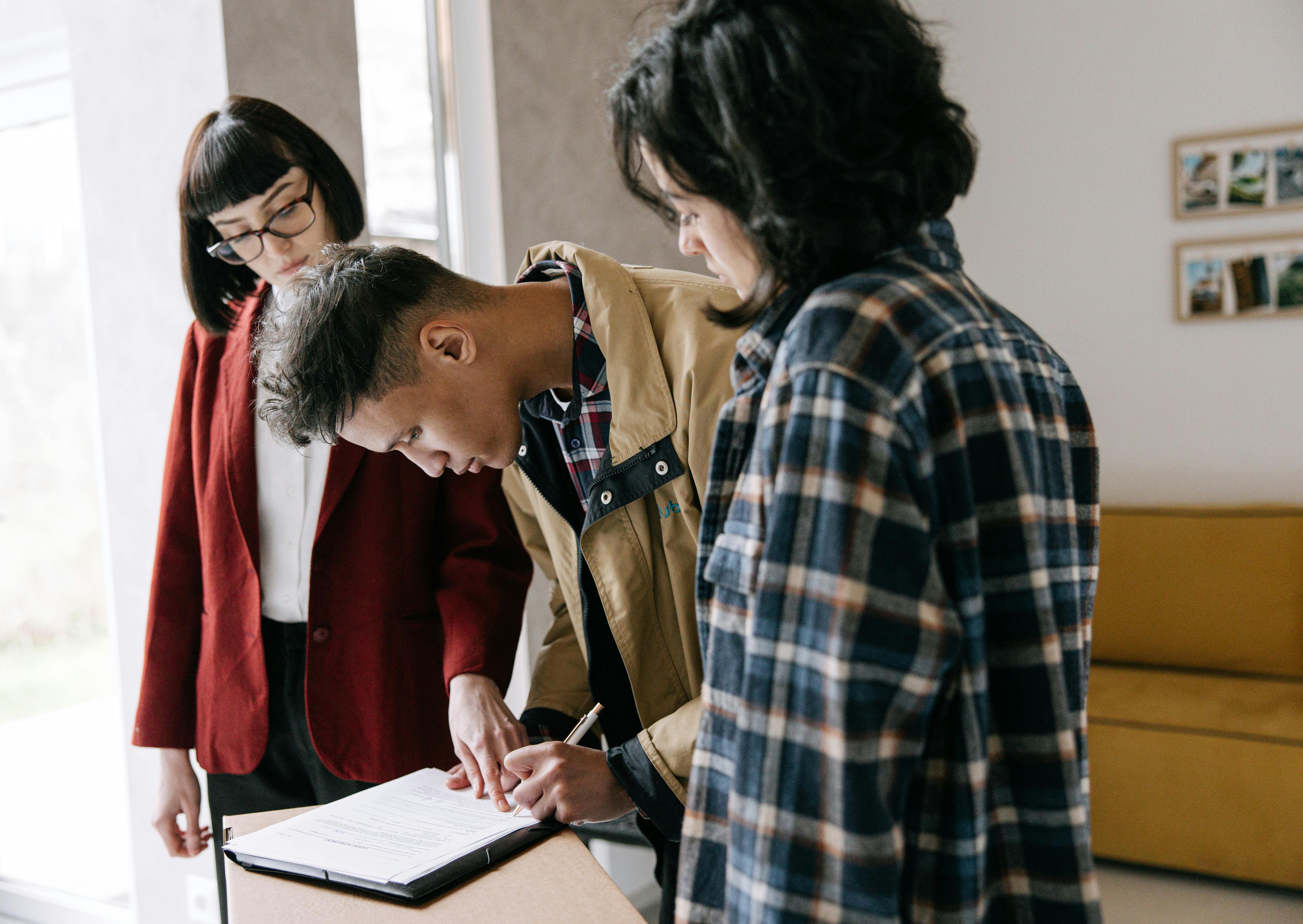 The picture shows a man signing the terms of a loan