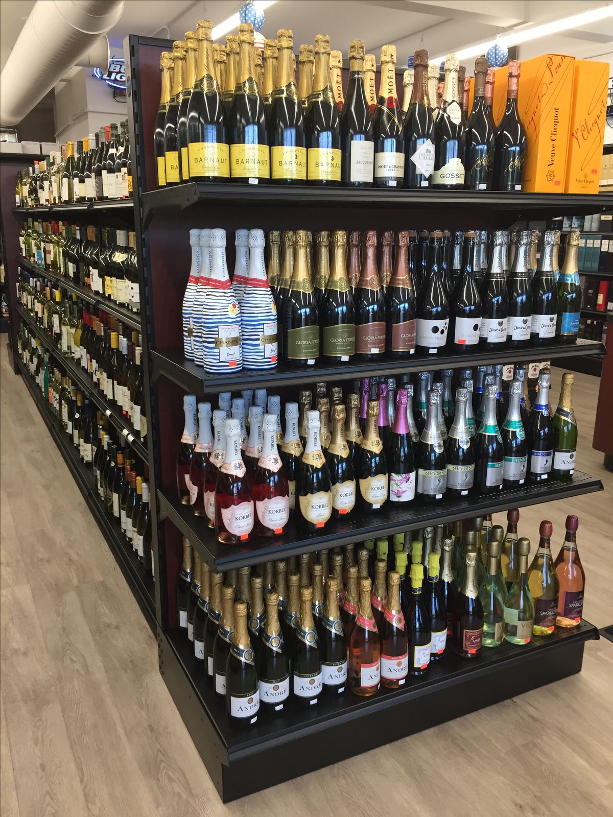 A display of assorted sparkling wines neatly arranged on shelves in a store.