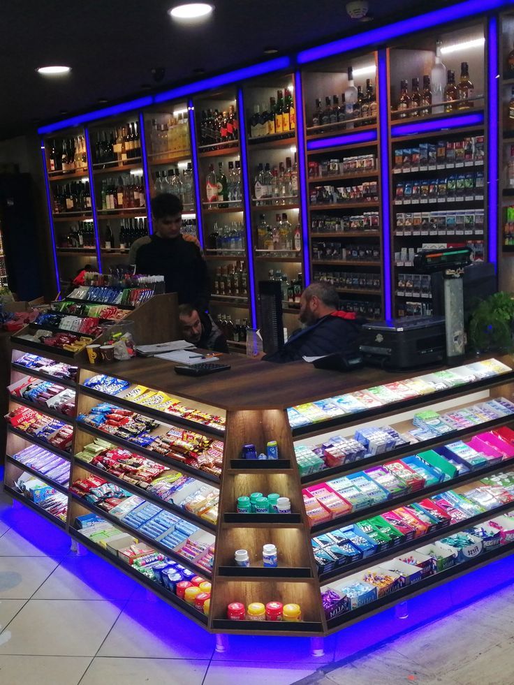 Liquor store checkout counter displaying snacks and beverages with staff assisting customers, representing merchant cash advance funding for liquor stores