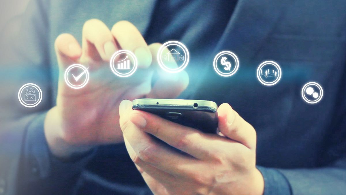 Business owner using a smartphone with digital finance icons, representing business loans for acquiring new technology or equipment to improve operations and growth.