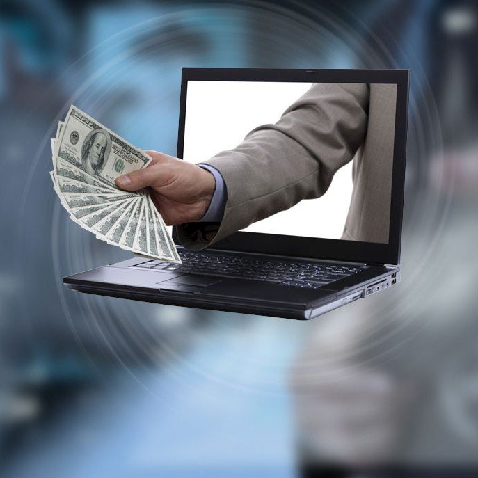 A hand emerges from a laptop holding cash, symbolizing online money transfer or digital earnings.
